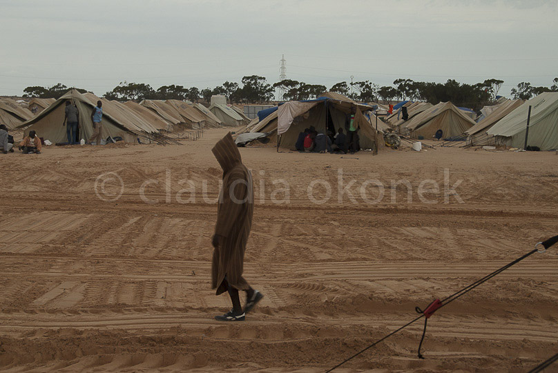 Sandsturm färbt die Zelte rot | Starke Regenfälle haben das Camp überschwemmt. Ein permanenter Sandsturm macht den Menschen zu schaffen.  |  Langeweile und ungewohntes Essen lassen Aggressionen aufkommen. Andauerndes Warten ohne Informationen bringt das Gefühl der Ausweglosigkeit.