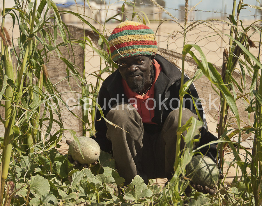 Lagerbewohner mit selbstgezogenen Melonen | Asylsuchender aus Äthiopien. Er hält die ersten Früchte aus seinem Garten in der Hand. Seit acht Monaten lebt er im Lager, auch für ihn gibt es noch keinen Aufenthaltsort.  |  