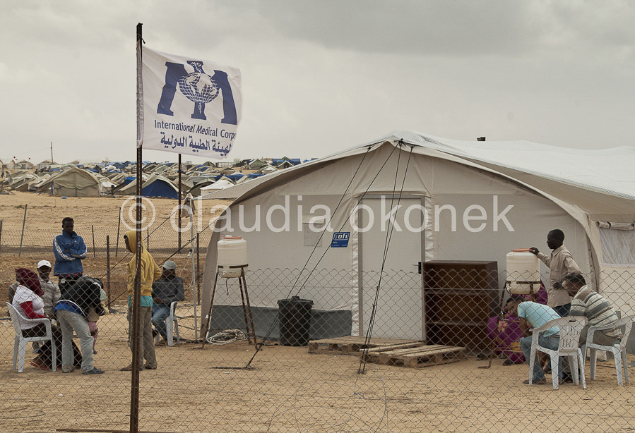 IMC Krankenstation, Choucha Camp | Flüchtlinge warten vor dem Zelt des International Medical Corps auf ihre Behandlung.  |  Choucha Camp. In den Zelten des IMC und des Militärs werden die Kranken versorgt. In Notfällen wird hier der Transport in die umliegenden Krankenhäuser vorbereitet.