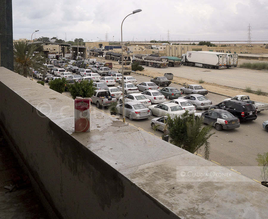 Fahrzeuge aus Libyen warten am Grenzübergang Ras Ajdir |   |  Das tunesische Militär überwacht die Transitstrasse nach Libyen , sie führt am Choucha Camp vorbei bis zum Grenzübergang Ras Ajdir. Häufig kommt es hier zu Unruhen und Blockaden durch aufgebrachte Tunesier und Libyer.