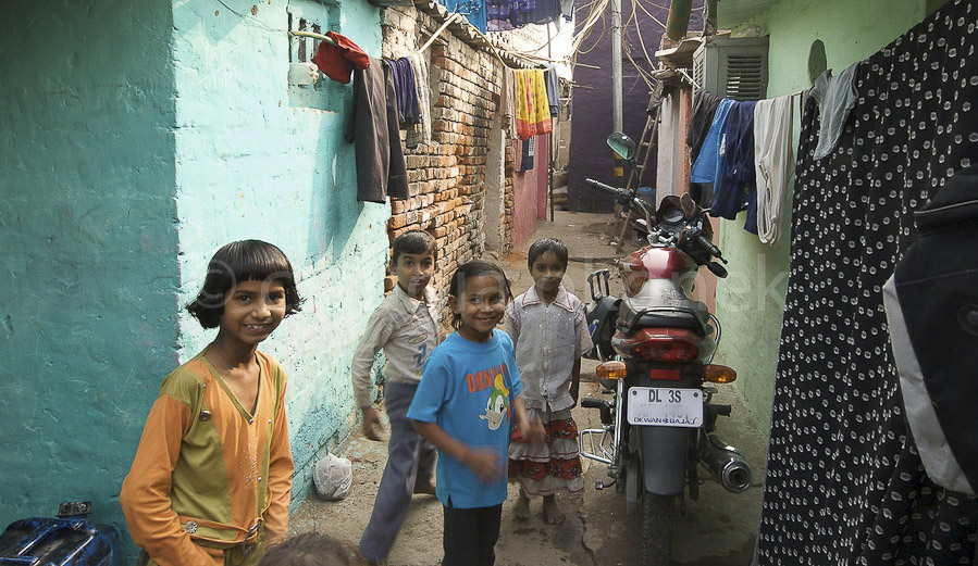Strasse mit Kindern und Motorrad | Weg zwischen den Häusern in einem Slum. Nicht alle Bewohner eines Slums sind mittellos. Viele arbeiten in den nahegelegenen Vierteln der Mittelklasse.  |  